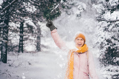 Portrait of young woman standing in snow