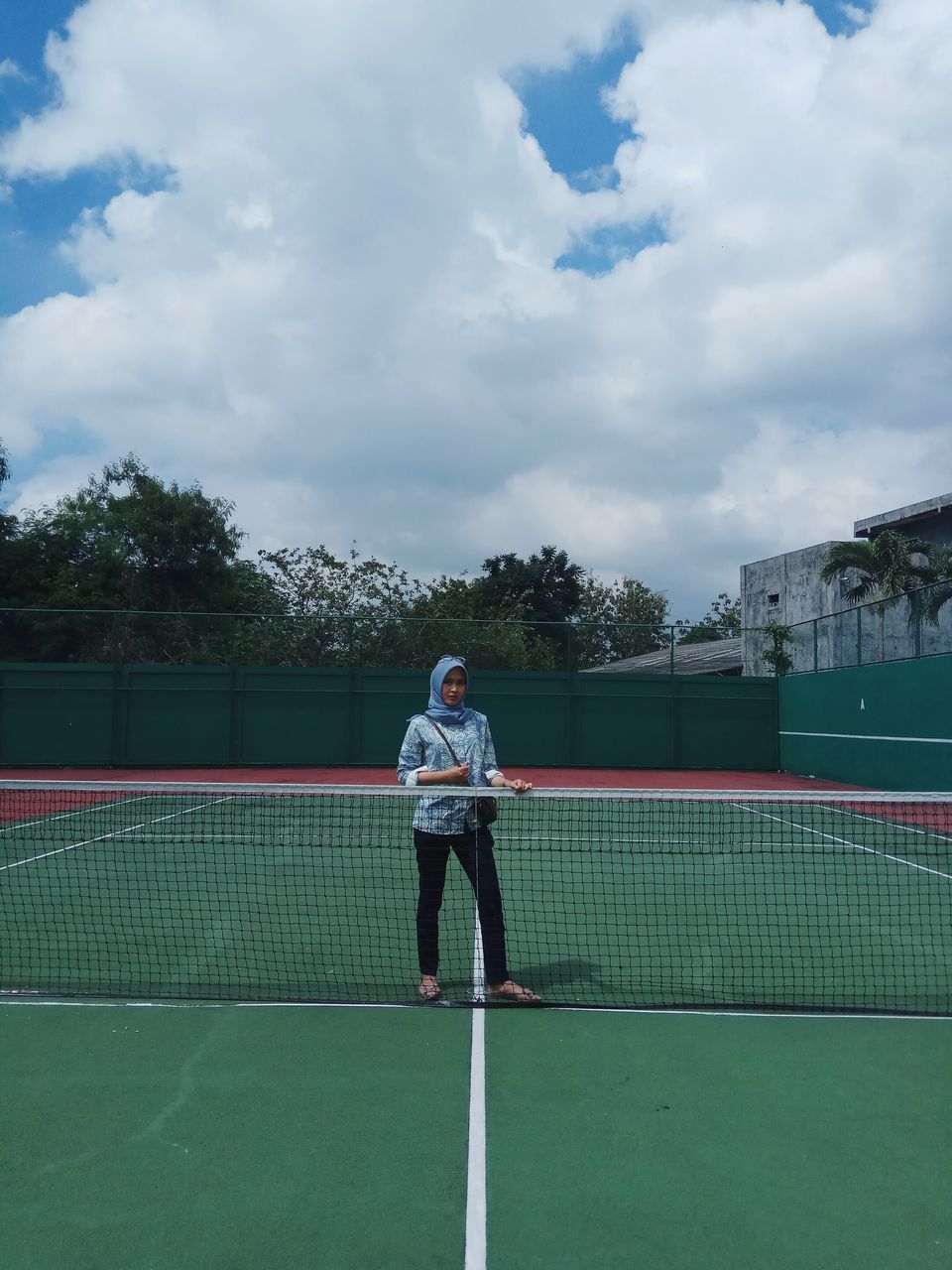 sport, playing, tennis, cloud - sky, leisure activity, real people, tennis racket, sky, lifestyles, court, full length, tennis ball, one person, outdoors, boys, day, standing, tennis net, childhood, ball, sports clothing, racket sport, tree, sportsman, young adult, people