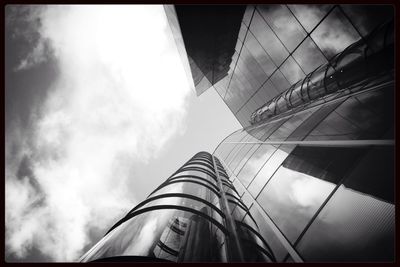 Low angle view of modern building against cloudy sky