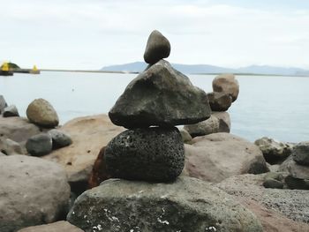 Close-up of rocks in sea against sky