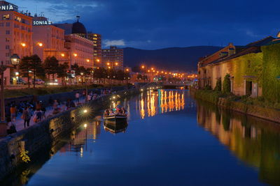 River amidst illuminated buildings in city at night