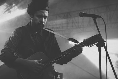 Man performing on stage amidst smoke