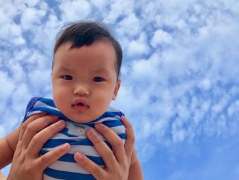 Portrait of cute baby girl against blue sky