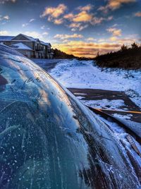 Scenic view of frozen lake against sky during sunset