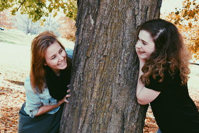 Young female friends playing hide and seek at park