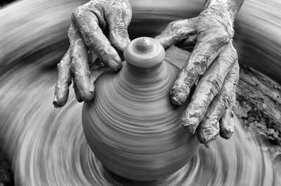 Cropped hands of man molding pot at workshop