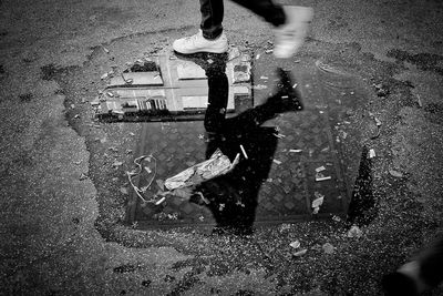 Low section of man with reflection in puddle