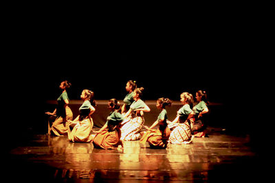 Group of people playing guitar against black background