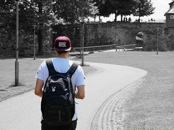 Rear view of boy standing by tree