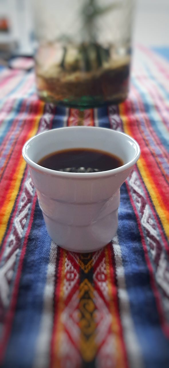 drink, food and drink, cup, mug, tea, hot drink, indoors, refreshment, tea cup, selective focus, no people, close-up, multi colored, tablecloth, red, pattern, textile, table, art, food, tradition, focus on foreground, ceramic, crockery