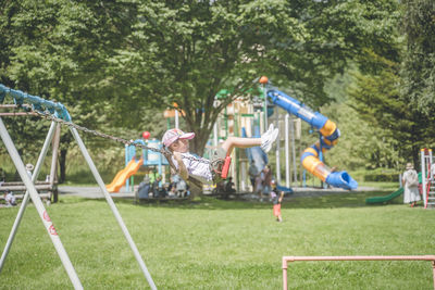 Children playing trapeze on field