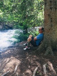 Man sitting on rock in forest