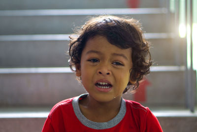 Close-up of boy crying while sitting on steps