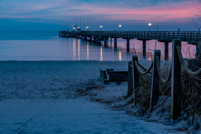 Pier on sea against sky at dusk