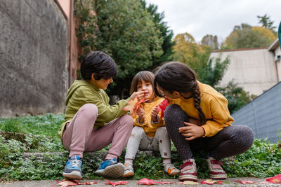 Two elder sisters cleaning the face of younger sister