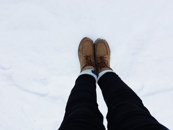 Low section of man standing on snow