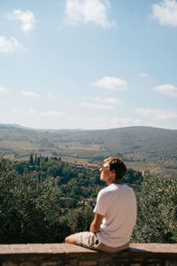 Rear view of woman sitting on mountain