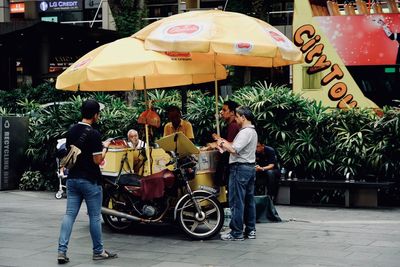 People sitting on street in city