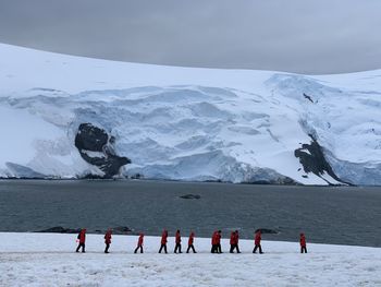 Rear view of people on snowcapped mountain