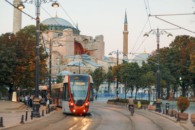 Tramway on street against buildings in city