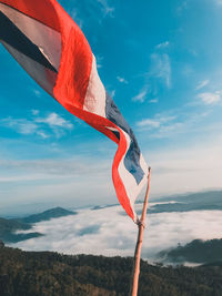 Low angle view of flag on mountain against sky