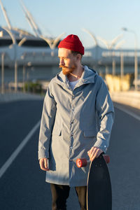 Young man wearing hat standing against sky