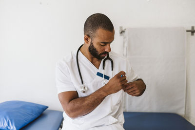 Portrait of male doctor keeping pen in pocket