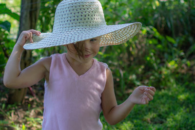 Midsection of woman wearing hat on field