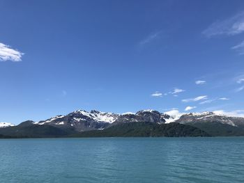 Scenic view of snowcapped mountains against blue sky