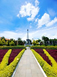 View of flowering plants in garden against cloudy sky