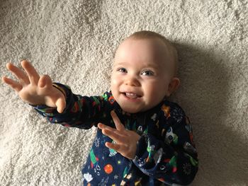 High angle view of cute baby boy lying on bed