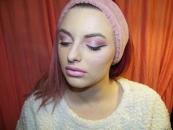 Close-up of young woman wearing make-up at home