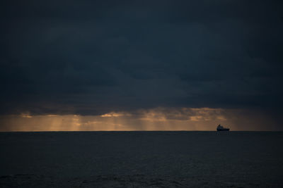 Scenic view of sea against storm clouds