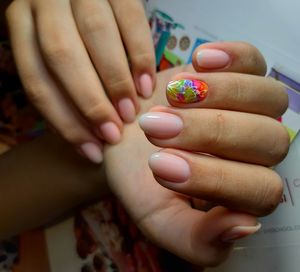 Cropped hands of woman showing nail art