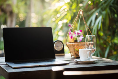 Coffee cup and laptop on table social distances concept 