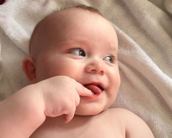 Close-up of cute baby boy lying on bed