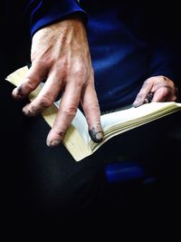 Close-up of dirty hands holding book