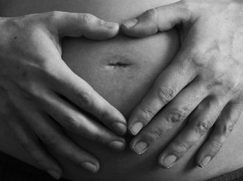Cropped hands of pregnant woman touching abdomen