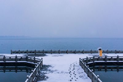 Scenic view of swimming pool by sea against clear sky