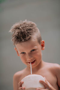 Portrait of shirtless boy drinking coffee