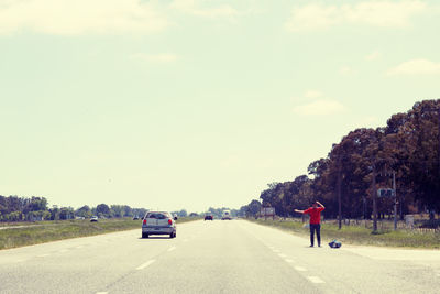 Rear view of man on road against sky