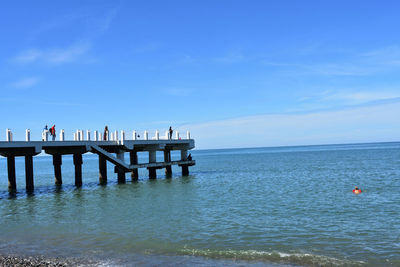 Pier over sea against blue sky