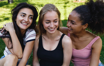 Happy friends sitting at park