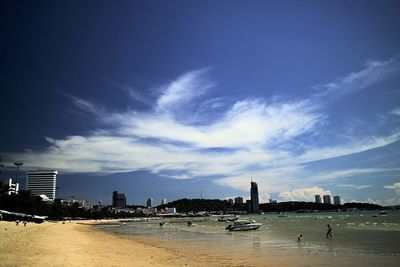 Boats in sea with city in background