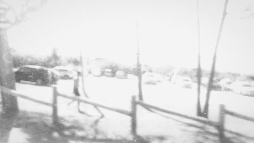 Cars on street against clear sky during winter