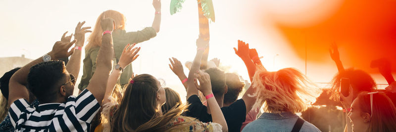 Panoramic view of male and female fans enjoying at music concert