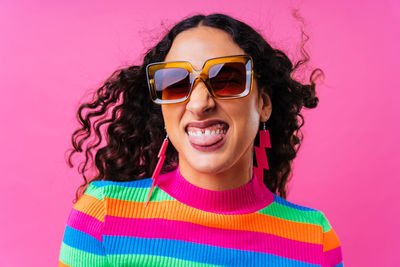 Portrait of woman wearing sunglasses against yellow background