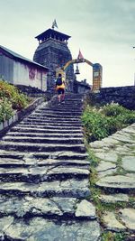 Staircase by temple against sky
