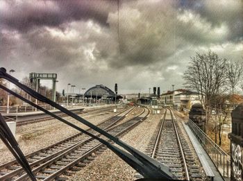 Railroad tracks against cloudy sky