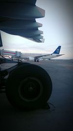 Close-up of airplane on runway against sky